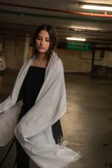 Pashmina de tejido ligero con acabado metalizado en tono oscuro, con bordes desflecados.