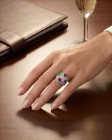 Anillo de plata 925 con diseño bombe, completamente pavimentado con circonias blancas y decorado con cuatro piedras naturales ovaladas: rubí, esmeralda y zafiro azul.