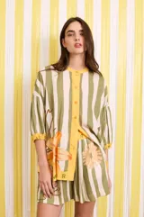 Short con estampado a rayas verticales en tonos verde y blanco, con cintura elastizada y detalle de estampado floral y texto.