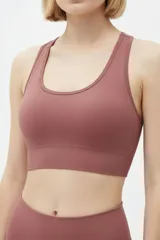 Top deportivo negro de tejido acanalado, con escote redondo y diseño ajustado al cuerpo.