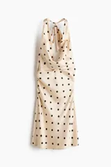 Vestido corto de crepé de satén color beige con estampado de lunares negros, escote drapeado halter con tiras para anudar al cuello y fruncidos laterales.