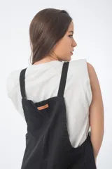 Mono negro de denim con corte oversize, breteles anchos y piernas anchas.