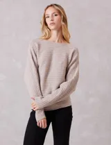 Buzo de punto acanalado horizontal con textura suave. Presenta un calce holgado, escote a la base y diseño de manga japonesa con caída fluida.