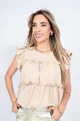 Blusa color beige con escote cuadrado, mangas cortas con volados y corte escalonado con volados.
