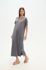 Vestido midi de corte holgado, color negro, con mangas cortas, cuello en V y detalle de cuentas decorativas en el escote.