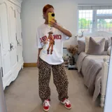 Remerón blanco con estampa de una vaquera y texto en color marrón.