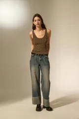 Musculosa de tejido de punto color marrón, con breteles anchos, cuello redondo y detalle de pequeñas cuentas metálicas distribuidas por toda la prenda.