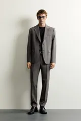 Pantalón de vestir regular fit color gris con sutil patrón a cuadros, confeccionado con mezcla de lana. Cuenta con bolsillos frontales, bolsillos traseros de doble vivo con botón, trabillas para cinturón y raya marcada en las piernas.