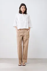Blusa blanca con cuello mao y mangas 3/4. Presenta apliques circulares bordados en el frente.