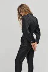 Camisa negra de popelina de algodón con cuello mao, mangas largas abullonadas y botones de nácar. Presenta corazones bordados y aplicados en el frente.