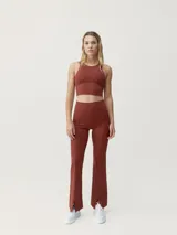 Top deportivo cropped color ladrillo, de sujeción media alta, con patrón minimalista y elegante.