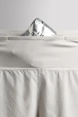 Short deportivo de trail running confeccionado en tejido técnico elástico con textura. Presenta una cintura elástica ancha con compartimentos integrados, bolsillo trasero con cierre y aberturas laterales en el bajo.
