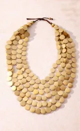 Collar largo de múltiples capas compuesto por discos circulares de madera en color negro, con diseño orgánico y liviano.