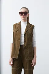 Chaleco de estilo utilitario color bordó con pespuntes blancos a contratono. Presenta solapas, cierre frontal con botones, bolsillos delanteros y un diseño estructurado.