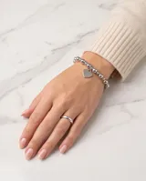 Pulsera de esferas metálicas de plata con dije colgante en forma de corazón.