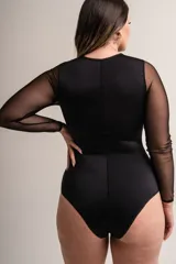 Body negro de lycra con escote cuadrado y mangas largas de microtul. Detalle frontal con puntilla combinada y ballenas. Broches en entrepierna con fundillo en algodón 100%.