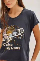 Remera de algodón color gris oscuro con cuello redondo y mangas cortas. Presenta un estampado frontal con motivos celestiales de sol, luna y nubes, con detalles de lentejuelas y la inscripción 'Claire de Lune'.