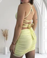 Vestido corto amarillo pastel con breteles finos, escote en V y frunces verticales en el centro.