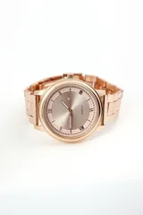 Reloj de pulsera dorado rosado con correa de eslabones y esfera redonda con números romanos.