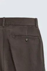 Pantalón chino de corte regular fit, confeccionado en tejido de algodón con estructura diagonal. Presenta bolsillos frontales, bolsillos traseros de vivo con botón y cierre frontal con cremallera y botón.