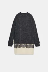 Vestido de cuello redondo y manga larga, confeccionado en tejido de punto gris oscuro. Presenta un bajo en contraste de color beige con detalle de encaje floral negro y lazada lateral ajustable.