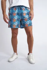 Short de baño con cintura elástica y cordón ajustable, confeccionado en tela ligera de secado rápido. Presenta un estampado botánico integral en tonos amarillos, blancos y azules, con dos bolsillos delanteros y uno posterior.