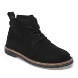 Bota tipo chukka de gamuza negra con cordones al tono, suela de goma dentada y detalle de borde de corcho en la entresuela.