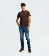 Pantalón de jeans azul de corte skinny, confeccionado con algodón, poliéster y elastano. Presenta un lavado medio con desgaste sutil y cierre tradicional.