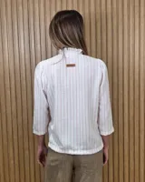 Camisa de algodón color blanco, con cuello alto con volados, mangas tres cuartos con detalles de bordado ingles y cierre frontal con botones de nácar.