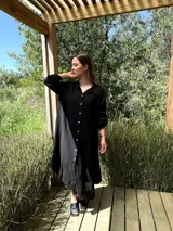 Vestido camisero negro amplio y largo, fabricado en Italia, con botones de nácar y bolsillos laterales. Fabricado en lino.