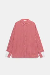 Camisa de cuello solapa y manga larga con rayas verticales rojas y blancas, con puños anchos blancos contrastantes y cierre frontal de botones.