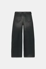 Jeans de mezclilla de tiro medio, corte wide leg y diseño relaxed. Presenta detalles rotos y desgastados en las piernas, y una cinturilla doblada superpuesta con trabillas y cierre frontal con cremallera y botón metálico.
