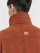 Sobrecamisa de micropolar color terracota, con cuello camisero, cierre frontal con botones a presión y dos bolsillos frontales con solapa y botón.