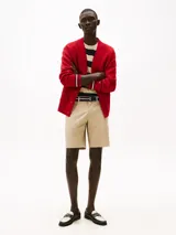 Pantalón corto beige tipo chino de Tommy Hilfiger, con bolsillos laterales y traseros, confeccionado en sarga de algodón y elastano. Incluye trabillas para cinturón.