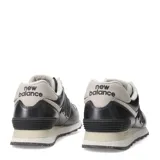 Championes urbanos New Balance modelo 574, color gris metalizado con detalles en crema y blanco. Presentan el logo N característico en los laterales, cordones al tono y suela con tecnología de amortiguación.