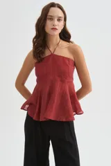 Top halter color amarillo claro, con escote strapless y detalle de argolla en el cuello, confeccionado en viscosa con diseño holgado y acabado fluido.