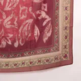 Pashmina color bordó con diseño estampado de guardas ornamentales y detalles florales en tonos beige y verde.