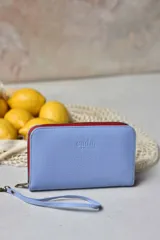 Billetera mediana celeste de cuero con cierre rojo, marca CADA.