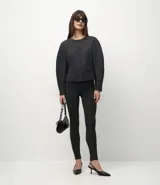 Pantalón tipo legging de tiro alto confeccionado en punto roma, con textura sutil y costuras frontales tipo nervura que estilizan la silueta.