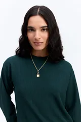 Remera de manga larga con textura acanalada, cuello redondo y calce relajado. Presenta un diseño minimalista en color verde oscuro.