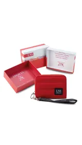 Billetera corta de diseño capitoneado con cierre perimetral y solapa frontal. Cuenta con compartimentos internos para tarjetas y billetes, e incluye una correa de mano desmontable.