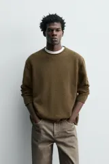 Jersey de punto de lana con corte regular fit, cuello redondo y manga larga. Presenta un diseño minimalista con acabados enrollados en cuello, puños y ruedo.