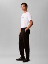 Pantalón de corte ceñido y largo al tobillo, confeccionado en tejido de tricot con cintura elástica. Presenta un diseño minimalista con logo de la marca bordado en el muslo.