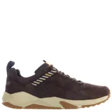 Championes de estilo urbano Caterpillar, confeccionados en gamuza color marrón tierra. Presentan una suela robusta de goma en tono beige y marrón, con detalles de cintas decorativas en amarillo y negro en la lengüeta y laterales.