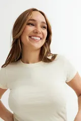 Remera básica de cuello redondo y manga corta, confeccionada en algodón, con un ajuste entallado al cuerpo.
