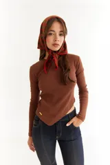 Top de manga larga color blanco, confeccionado en tejido de punto acanalado con diseño irregular y aberturas para los pulgares en los puños.