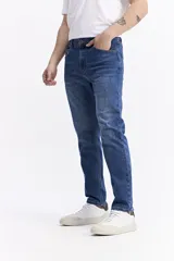 Jean de corte slim, con tiro medio, cierre frontal con botón y bolsillos laterales y traseros.