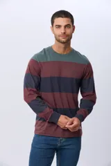 Remera de manga larga con diseño de rayas horizontales en tonos azul marino, beige y verde oscuro. Presenta cuello redondo y una pequeña estampa tipográfica en el pecho, además de una etiqueta decorativa en el ruedo.