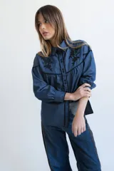 Camisa negra de manga larga con canesú estampado con diseño floral, cuello camisero y cierre frontal con botones.
