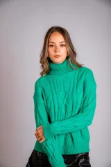 Suéter tejido de punto trenzado color salmón, con cuello alto y mangas largas. Corte ajustado al cuerpo.